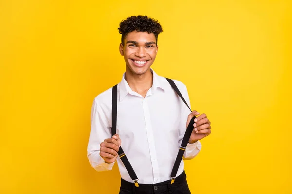 Afro-Amerikan bir adamın, sarı renkli arka planda izole edilmiş gülümseyen pantolon askılarını çekerken çekilmiş fotoğrafı. — Stok fotoğraf