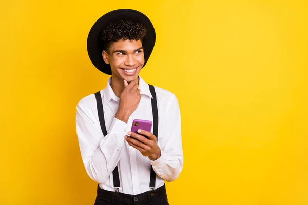 Portrait photo d'un homme afro-américain pensif tenant un téléphone regardant l'espace vide isolé sur fond jaune vif — Photo