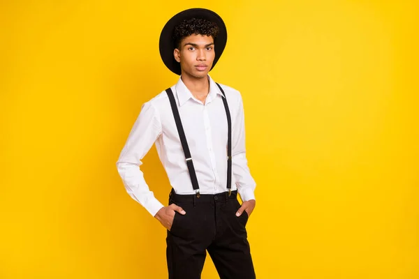 Foto de uno mismo-seguro fresco chico manos bolsillos desgaste sombrero camisa blanca tirantes aislados color amarillo fondo — Foto de Stock