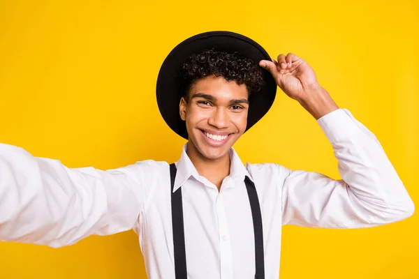 フォトポートレートのアフリカ系アメリカ人男取ります自分自身を保持帽子絶縁上の鮮やかな黄色の背景 — ストック写真