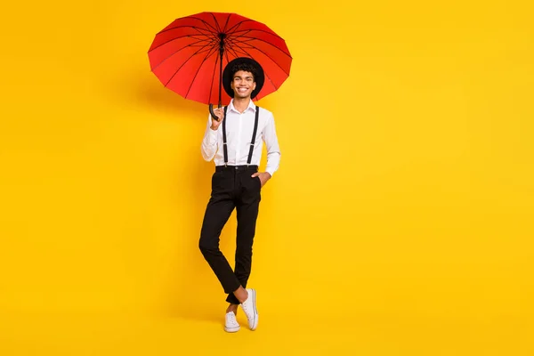 Retrato de foto de comprimento total do cara americano africano posando com guarda-chuva vermelho isolado no fundo colorido amarelo vívido — Fotografia de Stock