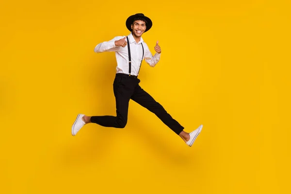 Full length photo portrait of african american guy showing thumb-up jumping up isolated on vivid yellow colored background — Stock Photo, Image