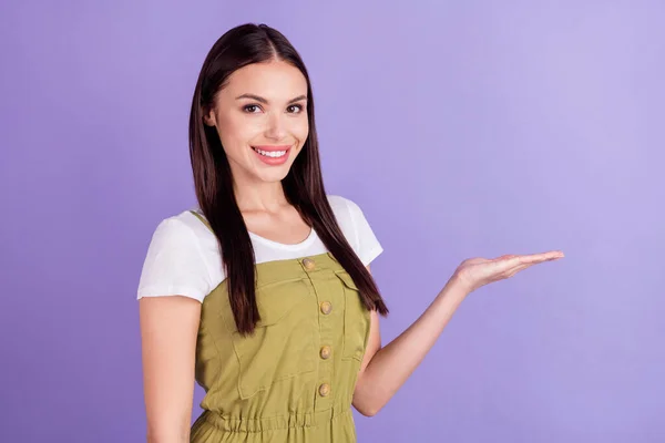 Foto von fröhlichen jungen glücklichen Frau halten Hand leeren Raum Verkauf entscheiden Angebot isoliert auf violettem Hintergrund — Stockfoto