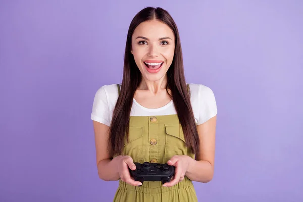 Foto van charmante mooie jonge vrouw dragen kaki algehele holding playstation geïsoleerde violette kleur achtergrond — Stockfoto