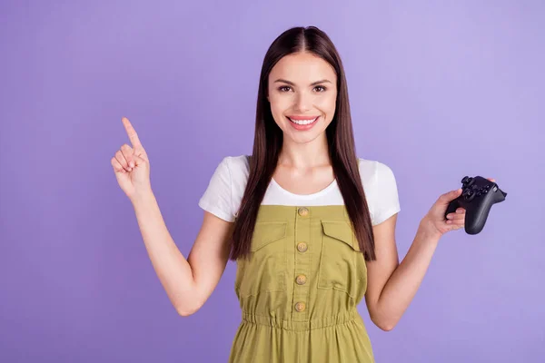 Foto van vrolijke vrolijke jonge vrolijke vrouw wijzen vinger lege ruimte houden joystick geïsoleerd op violette kleur achtergrond — Stockfoto