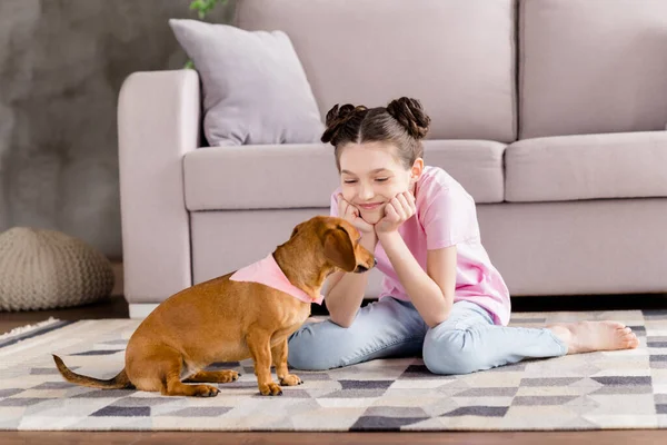 Portrait d'attrayant gai fille assis sur le sol jouer avec chiot passer du temps libre profiter de la vie à la maison appartement à l'intérieur — Photo