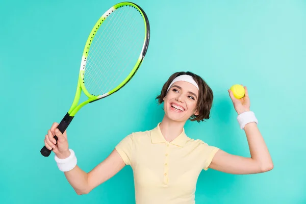 Foto van aantrekkelijke jonge tennisser vrouw houden racket bal dienen geïsoleerd op pastel teal kleur achtergrond — Stockfoto