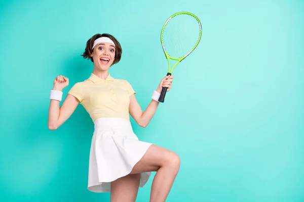 Foto van positieve verbaasd opgewonden jonge dame verhogen racket vuist win match geïsoleerd op pastel teal kleur achtergrond — Stockfoto