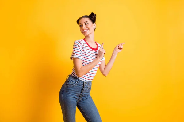 Foto de la optimista morena lady point look espacio vacío usar pantalones vaqueros aislados sobre fondo de color amarillo brillante — Foto de Stock