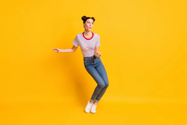 Foto van charmante mooie jonge meisje gekleed gestreept t-shirt op zoek lege ruimte dansen geïsoleerde gele kleur achtergrond — Stockfoto