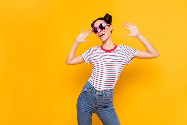 Foto di brillante divertente giovane ragazza vestita a strisce t-shirt occhiali scuri ballare spazio vuoto isolato colore giallo sfondo — Foto Stock