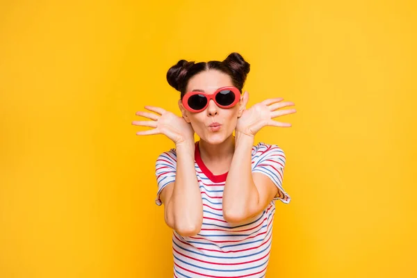 Φωτογραφία από αρκετά παιδαριώδη νεαρή γυναίκα φορούν ριγέ t-shirt σκούρα γυαλιά χορεύουν χέρια αυτιά χείλη pouted απομονωμένο κίτρινο χρώμα φόντο — Φωτογραφία Αρχείου