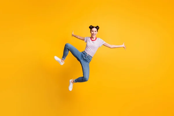Foto de comprimento total de muito adorável jovem vestida t-shirt listrada saltando alto isolado cor amarela fundo — Fotografia de Stock