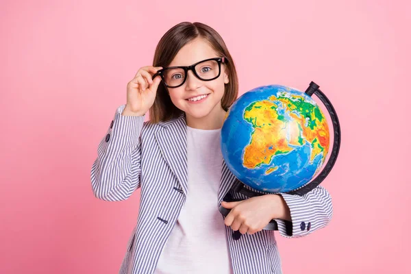 Portret van aantrekkelijke vrolijke meisje houden in handen globe lezing land verkennen geïsoleerd over roze pastel kleur achtergrond — Stockfoto
