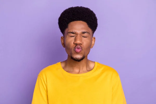 Портрет привлекательной нежной мечтательный парень посылает вам воздушный удар поцелуй пухлые губы изолированы на фиолетовый фиолетовый цвет фона — стоковое фото