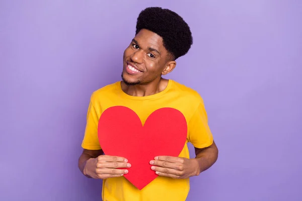 Retrato de atractivo chico alegre sosteniendo en las manos forma de corazón grande aislado sobre violeta color púrpura fondo — Foto de Stock