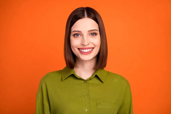 Foto de la divertida morena peinado milenial dama usar camisa verde aislado sobre fondo de color naranja — Foto de Stock