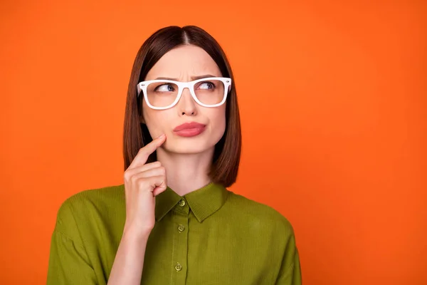 Фото брюнетки прическа юная леди выглядят пустой пространство носить очки рубашку цвета хаки изолированы на фоне оранжевого цвета — стоковое фото