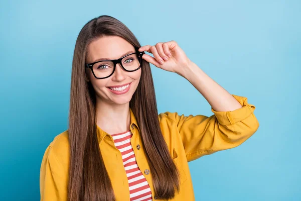 Fotografie mladé veselá žena šťastný pozitivní úsměv ruka dotykové brýle izolované přes modré barvy pozadí — Stock fotografie