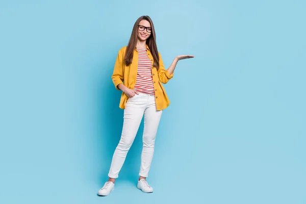 フルサイズの写真の若い魅力的な女性幸せなホールド手アドバイス製品提供隔離上青色背景 — ストック写真