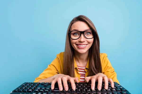 Fotografie mladé atraktivní ženy šťastný pozitivní úsměv vývojář klávesnice počítač izolovaný přes modré barvy pozadí — Stock fotografie