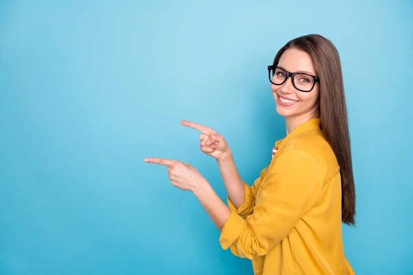 Perfil lado de la foto de la joven chica atractiva feliz sonrisa positiva punto dedos espacio vacío anuncio elección directa aislado sobre fondo de color azul — Foto de Stock