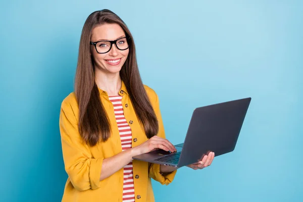Фото счастливой довольно позитивной молодой женщины держаться за руки ноутбук фрилансер изолирован на пастельно-голубом фоне цвета — стоковое фото