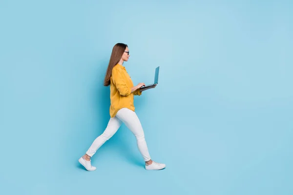 Πλήρες μέγεθος προφίλ πλευρά φωτογραφία της νεαρής γυναίκας των επιχειρήσεων ευτυχής θετικό χαμόγελο πάει τα πόδια laptop εργασίας απομονώνονται πάνω από το μπλε χρώμα φόντο — Φωτογραφία Αρχείου