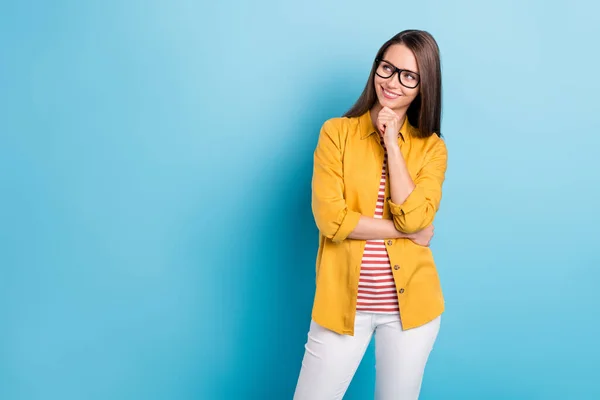 Photo de jeune femme séduisante heureux sourire positif main toucher menton regard curieux espace vide isolé sur fond de couleur bleue — Photo