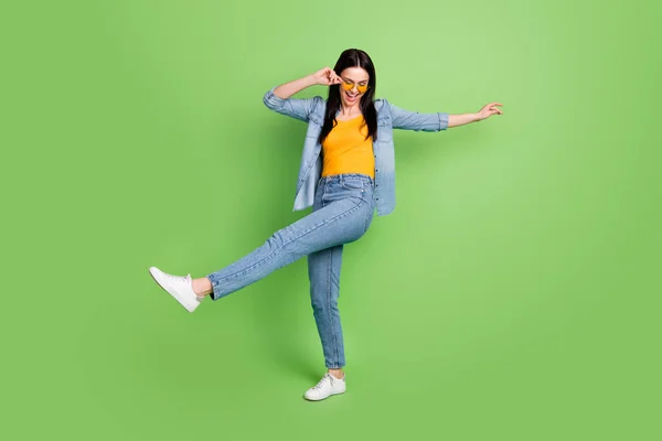 Full size photo of happy cheerful pretty lovely woman in sunglass silly dancing isolated on green color background — Stock Photo, Image