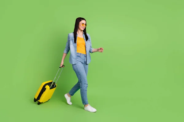 Foto lateral de perfil de tamaño completo de la mujer sonriente feliz ir a caminar con el equipaje de salir de vacaciones aislado en el fondo de color verde —  Fotos de Stock