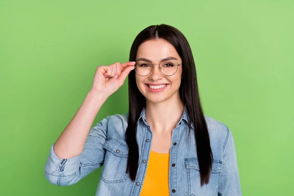 Foto di allegro smart marrone acconciatura signora touch occhiali indossare jeans camicia isolata su sfondo di colore verde — Foto Stock