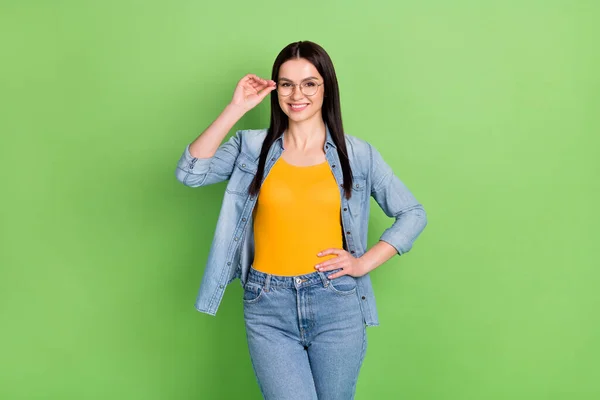 Foto di positivo bello marrone acconciatura signora indossare occhiali jeans camicia arancione superiore isolato su sfondo di colore verde — Foto Stock