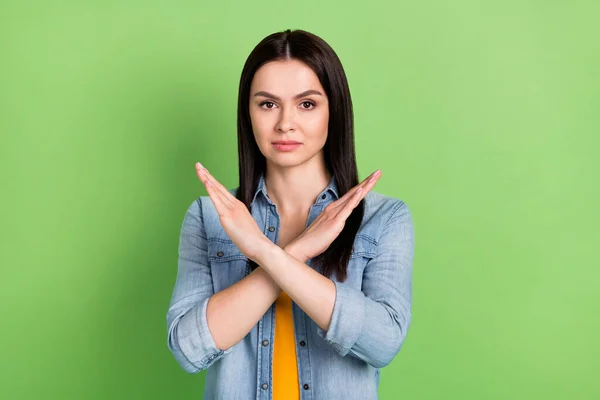 Foto de estricto bonito cabello marrón dama mano cruzada usar jeans camisa aislada sobre fondo de color verde pastel — Foto de Stock