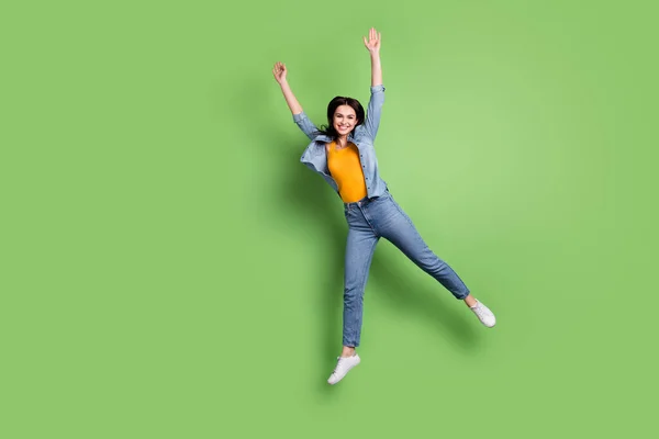 Full tělo fotografie funky pěkný hnědý účes dáma skok oblečení džíny košile izolované na pastelové zelené barvy pozadí — Stock fotografie