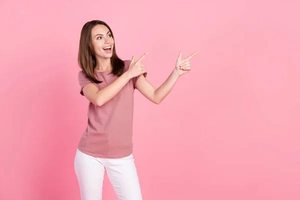 印象的なブルネットの若い女性の写真空のスペースはピンクの色の背景に隔離されたTシャツを着て見える — ストック写真