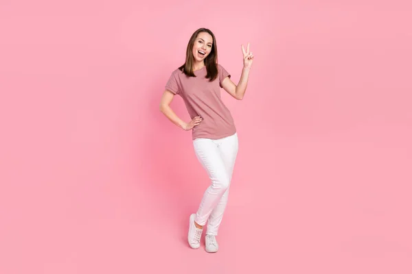 Vista completa del tamaño del cuerpo de la atractiva chica afortunada alegre mostrando v-signo aislado sobre fondo de color pastel rosa —  Fotos de Stock