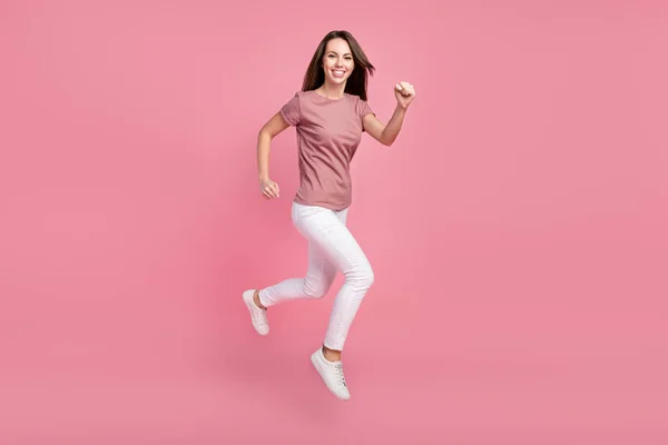 Teljes hossz testméret kilátás vonzó vidám lány ugrás futó aktív élet elszigetelt rózsaszín pasztell szín háttér — Stock Fotó