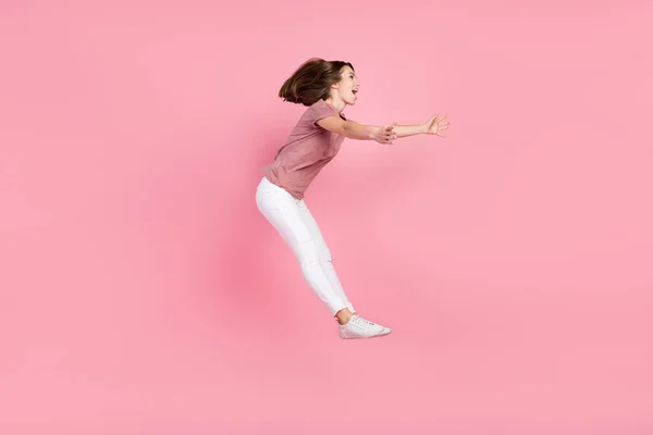 Longitud completa tamaño del cuerpo perfil vista lateral de la atractiva chica alegre saltando captura de espacio de copia aislado sobre fondo de color pastel rosa — Foto de Stock