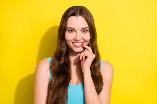 Foto porträtt leende glad flicka med långt hår i blå singlet vidröra läppar isolerad ljus gul färg bakgrund — Stockfoto