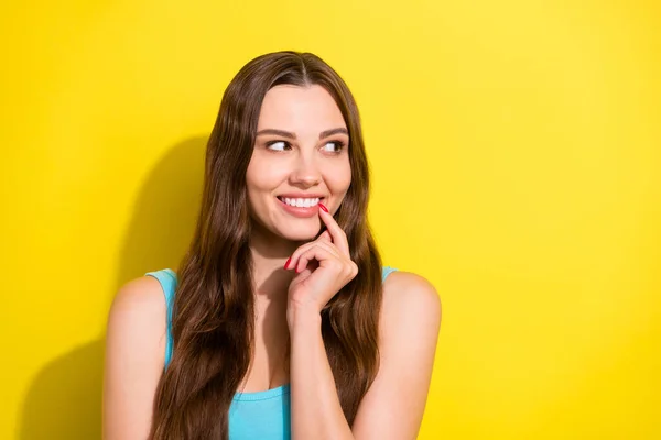 Portrét atraktivní veselá dívka kousání nehet hádání kopie prázdný prostor reklama izolované přes jasně žluté barvy pozadí — Stock fotografie