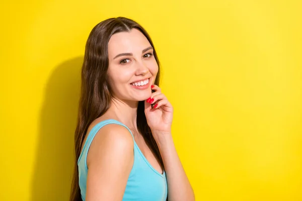 Foto retrato menina com cabelos longos vestindo roupas casuais sorrindo tocando queixo isolado vívido cor amarela fundo — Fotografia de Stock