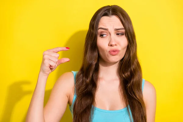 Foto van trieste brunette kapsel jonge dame tonen kleine maat slijtage teal top geïsoleerd op levendige gele kleur achtergrond — Stockfoto