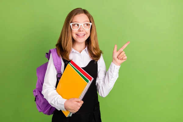 Portrait of beautiful trendy cheerful schoolkid showing copy space ad advert new novelty isolated over green color background — Foto de Stock