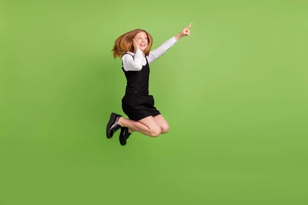 Volledige lichaamsomvang uitzicht van aantrekkelijke vrolijke onder de indruk meisje springen tonen kopieerruimte geïsoleerd over groene kleur achtergrond — Stockfoto