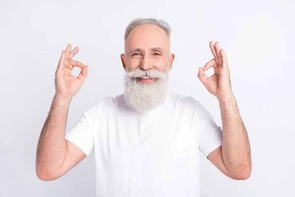 Ritratto di positivo capelli grigi barba vecchio mostra okey segno usura bianco t-shirt isolato su sfondo di colore grigio — Foto Stock