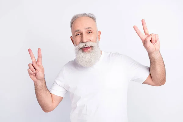 Portrait of positive grey hair beard old man show v-sign wear white t-shirt isolated on grey color background — Stock Photo, Image