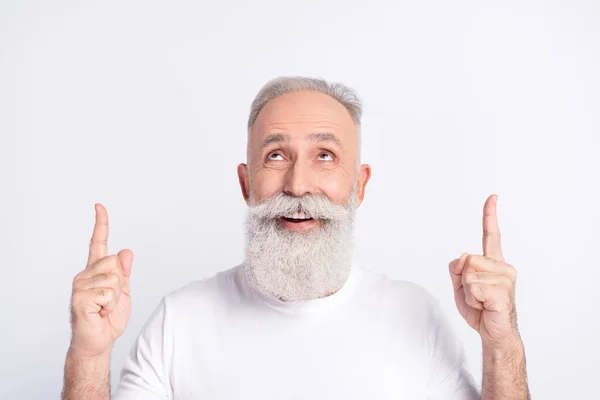 Portrait of attractive cheerful man demonstrating looking up copy space ad offer recommend isolated over white pastel color background — ストック写真