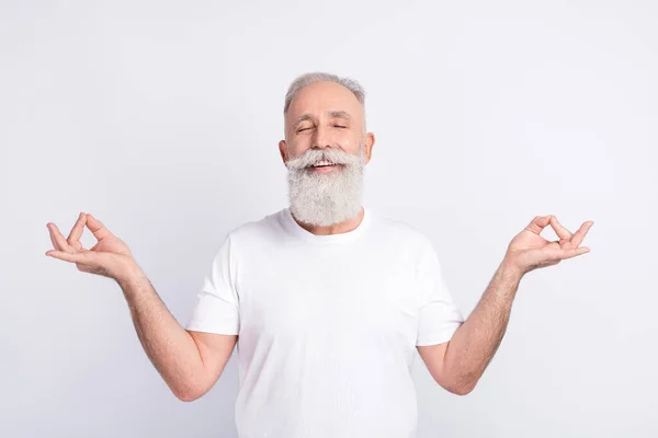 Portrait of positive grey hair beard old man crossed fingers wear white t-shirt isolated on grey color background — 图库照片