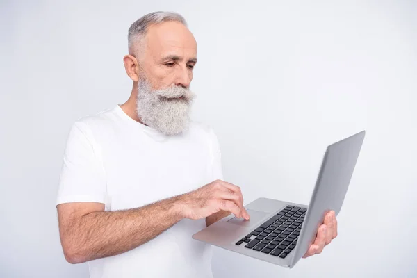 Zdjęcie poważnie uroczy starzec skupiony wygląd trzymać laptop praca wolny strzelec odizolowany na szarym tle kolor — Zdjęcie stockowe
